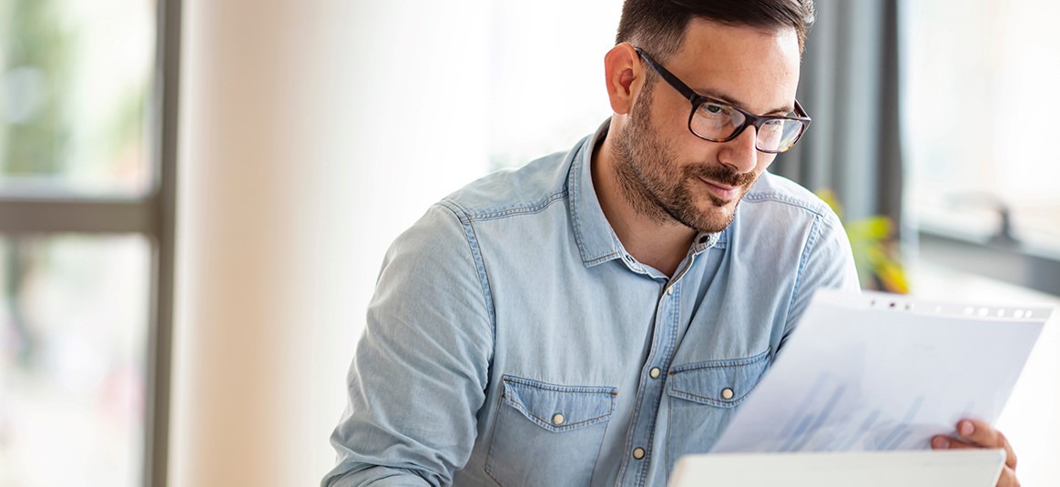 A man looking over some documents at his desk