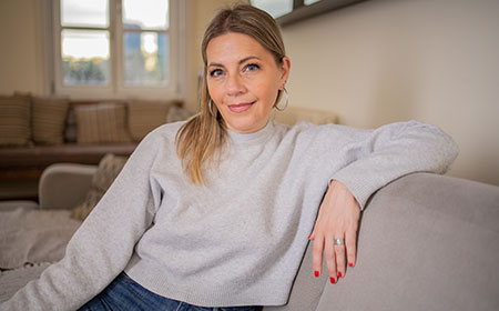 Woman sitting on a sofa looking directly at camera